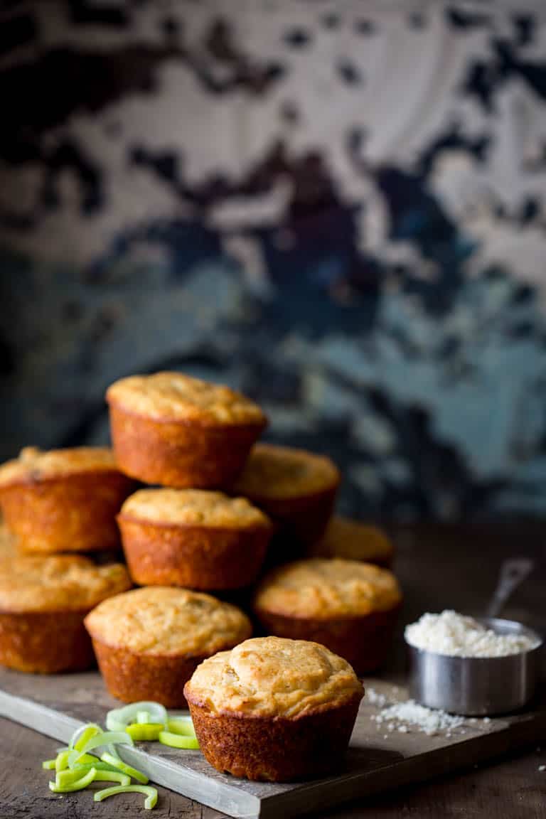 a stack of parmesan muffins on a slate board with blue mottled background