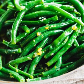 close up of green bean with orange zest on them
