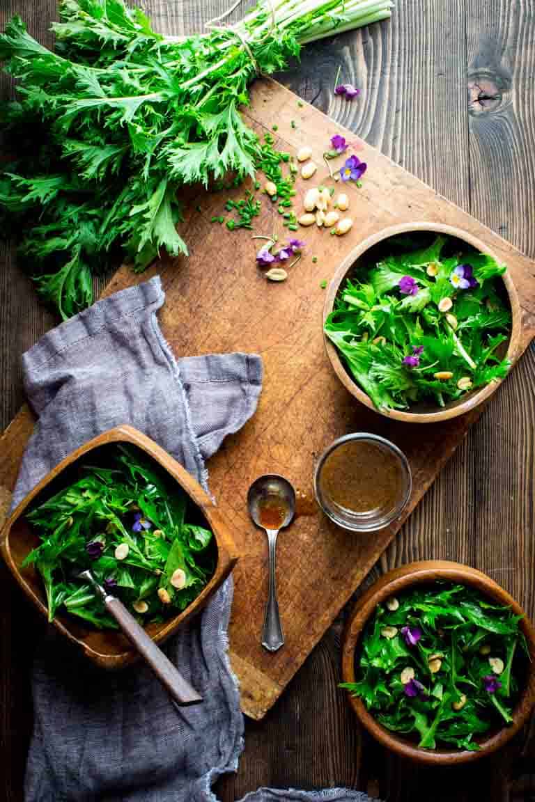 Mizuna recipe in serving bowls with dressing alongside