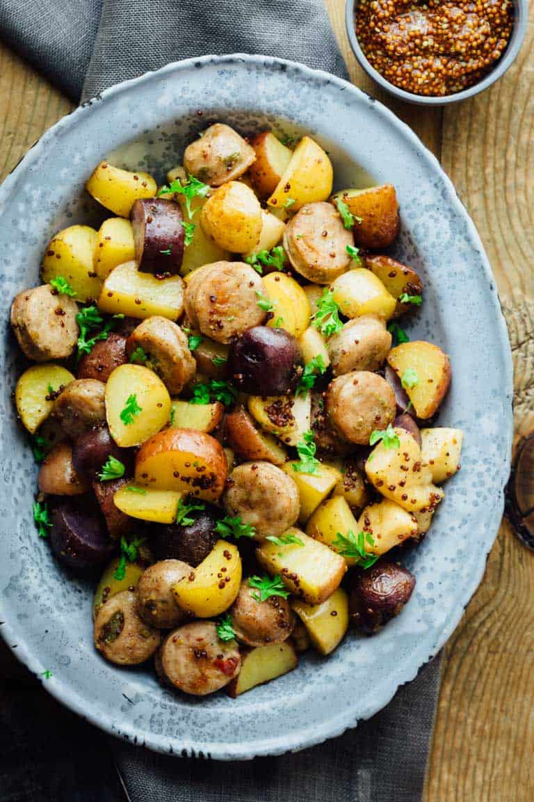 overhead shot of roasted potatoes, sausage, and apples garnished in a bowl