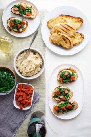 These super versatile and yummy White Bean Bruschetta with Garlicky Greens are the perfect little appetizer for your Spring and Summer get-togethers. | Healthy Seasonal Recipes | Katie Webster