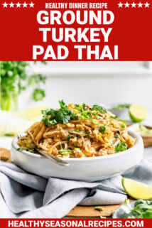 white bowl of pad thai noodles and fresh herbs