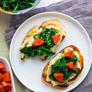 These super versatile and yummy White Bean Bruschetta with Garlicky Greens are the perfect little appetizer for your Spring and Summer get-togethers. | Healthy Seasonal Recipes | Katie Webster