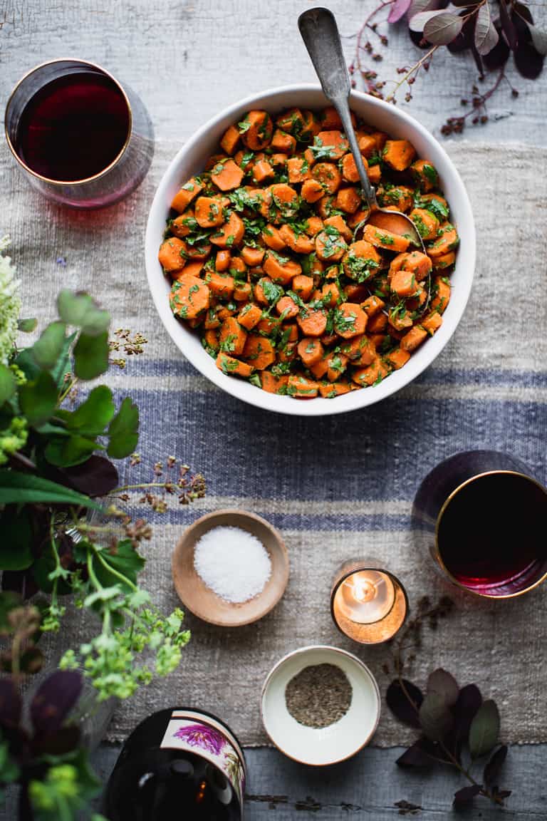 Moroccan Carrots on a farm table with flowers and red wine