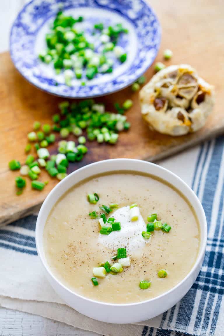 This Roasted Garlic Cheddar Soup will literally warm you up from the inside out! It is filled with yummy cheddar cheese and roasted garlic making it the perfect Winter comfort food and gluten free meal! | Healthy Seasonal Recipes | Katie Webster