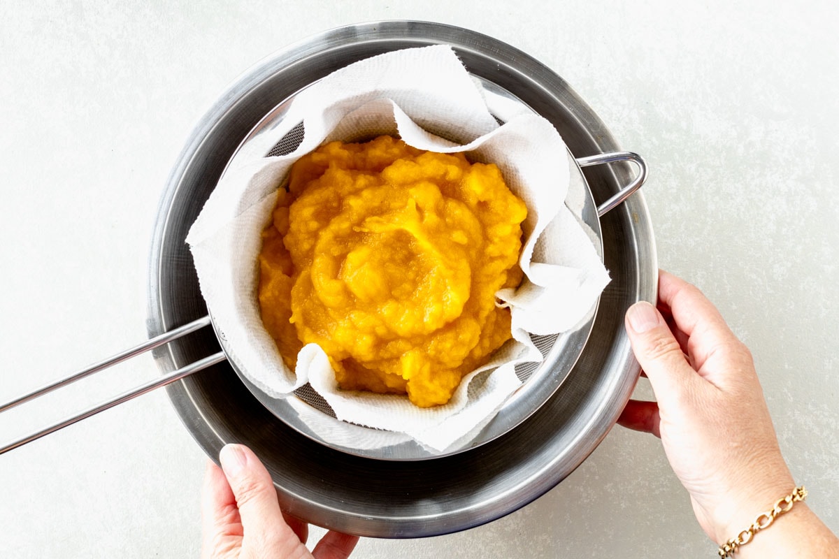 straining pumpkin puree to make it thicker