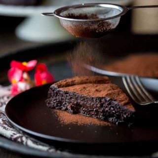 A close up of a piece of chocolate cake on a plate, with Flour