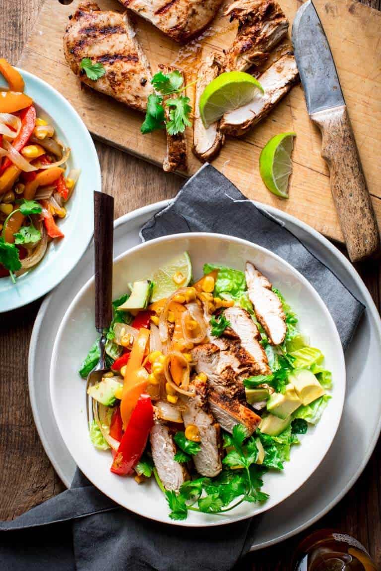 Grilled Chicken Fajita Salad in a large bowl next to a cutting board