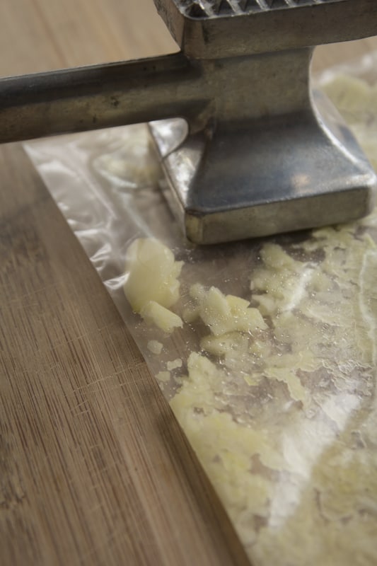 mashing the garlic in the bag to make the marinade