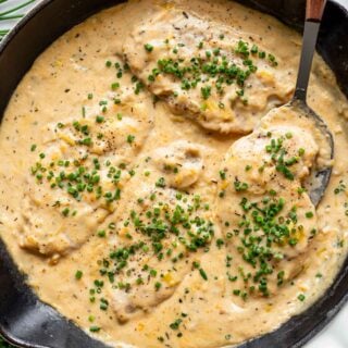 the chicken in the skillet with cheese sauce and chives sprinkled over it