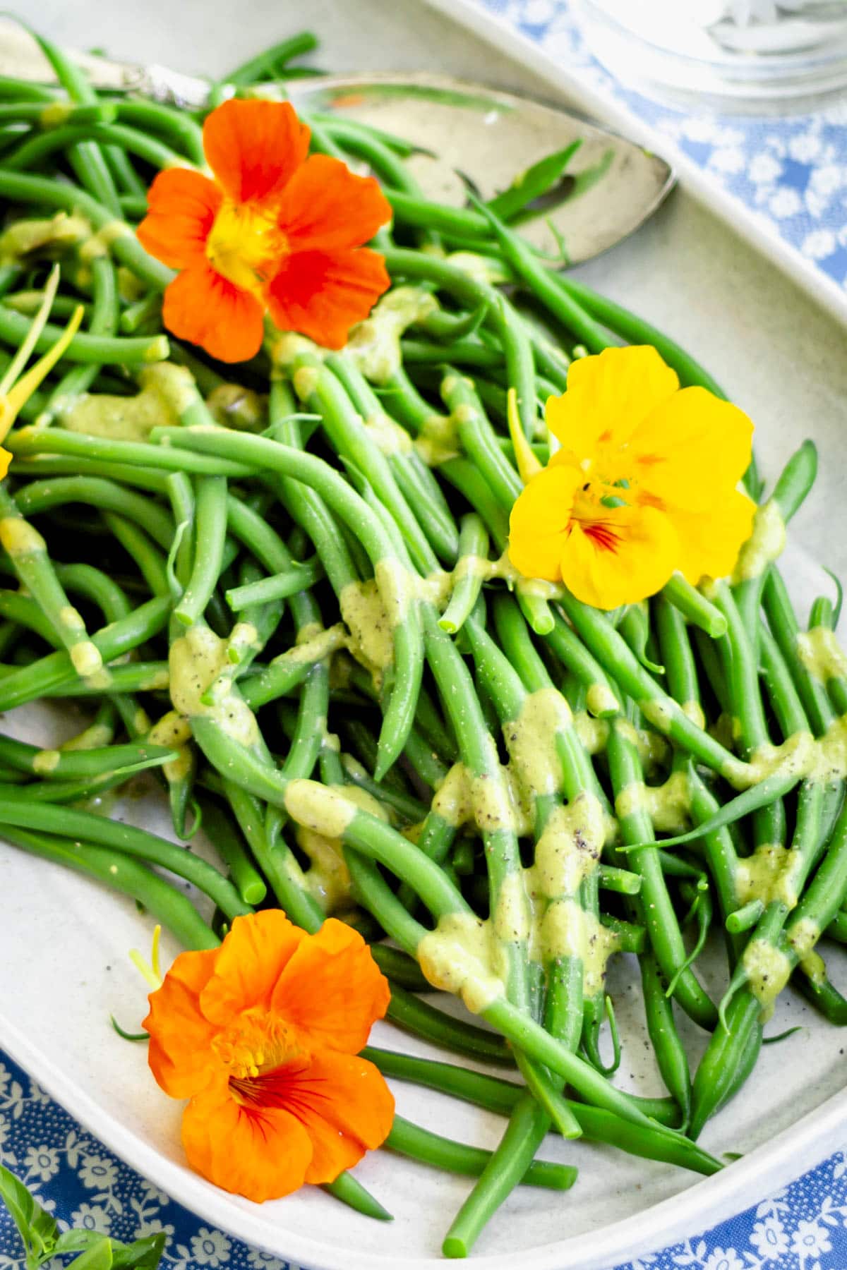 green beans with vinaigrette on a gray platter