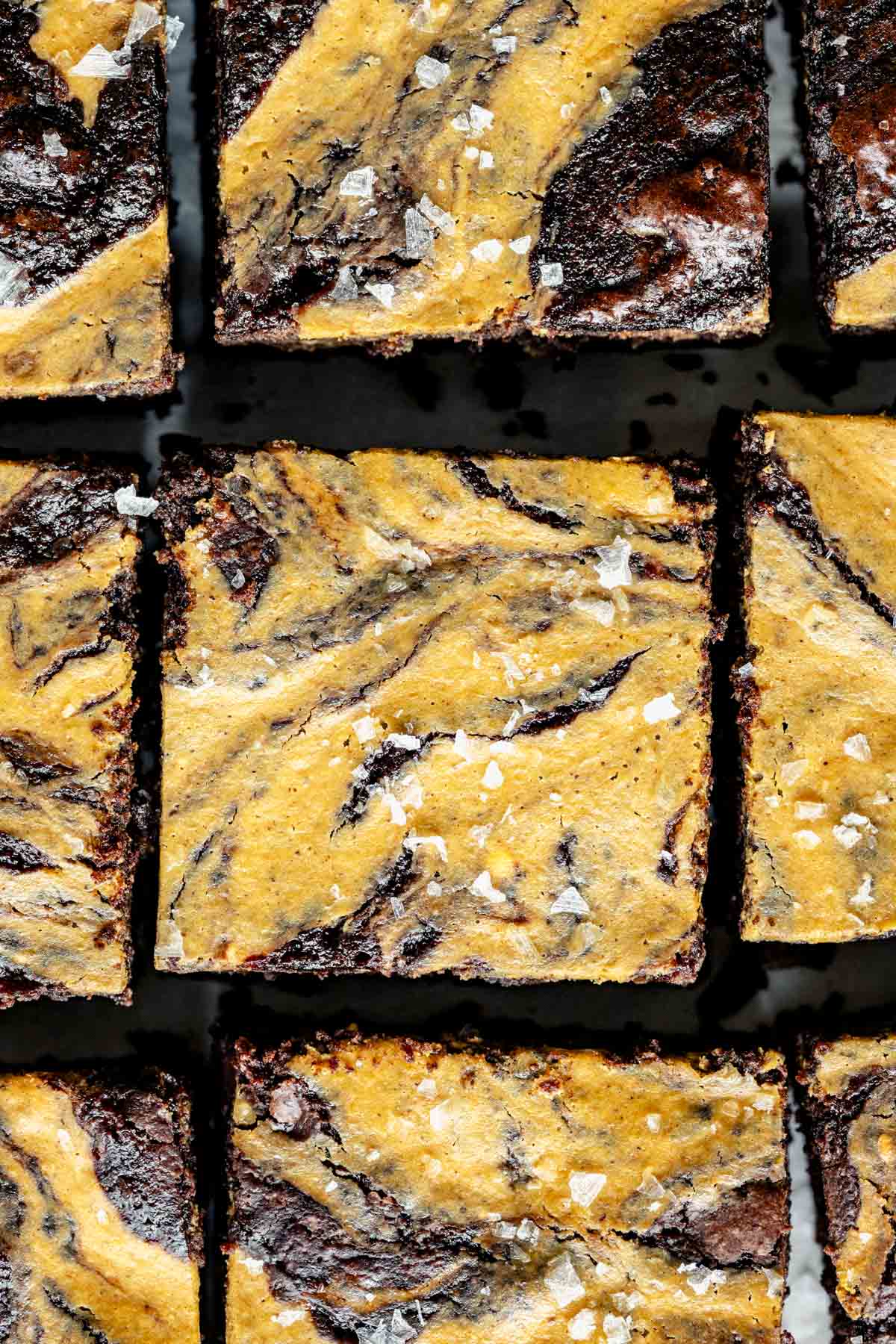 a close up of the pumpkin brownies with flaky salt on top