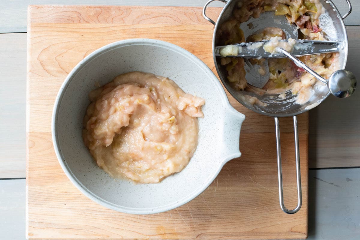 the applesauce in a bowl with the food mill next to it