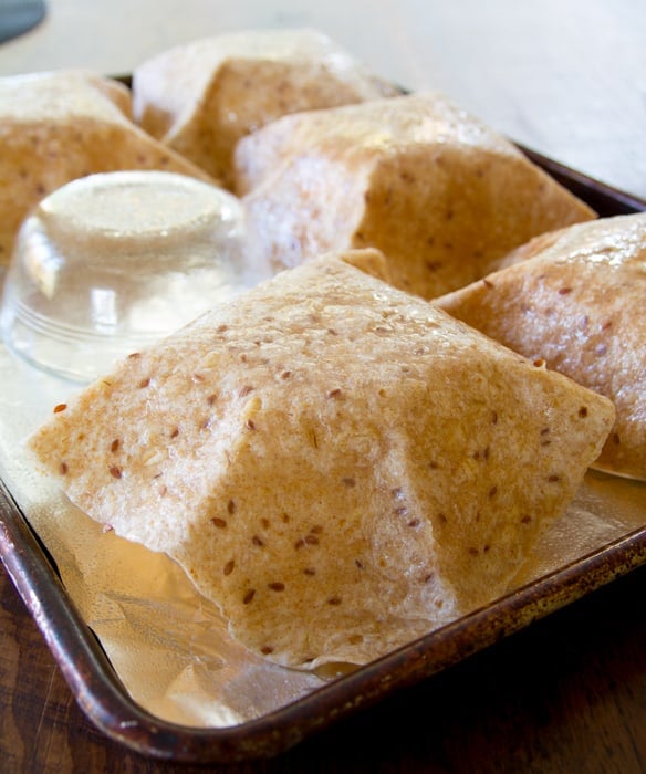 the tortillas draped over the ramekins for baking