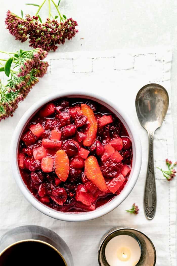 overhead view of cranberry sauce with apple and orange with sedum and a spoon