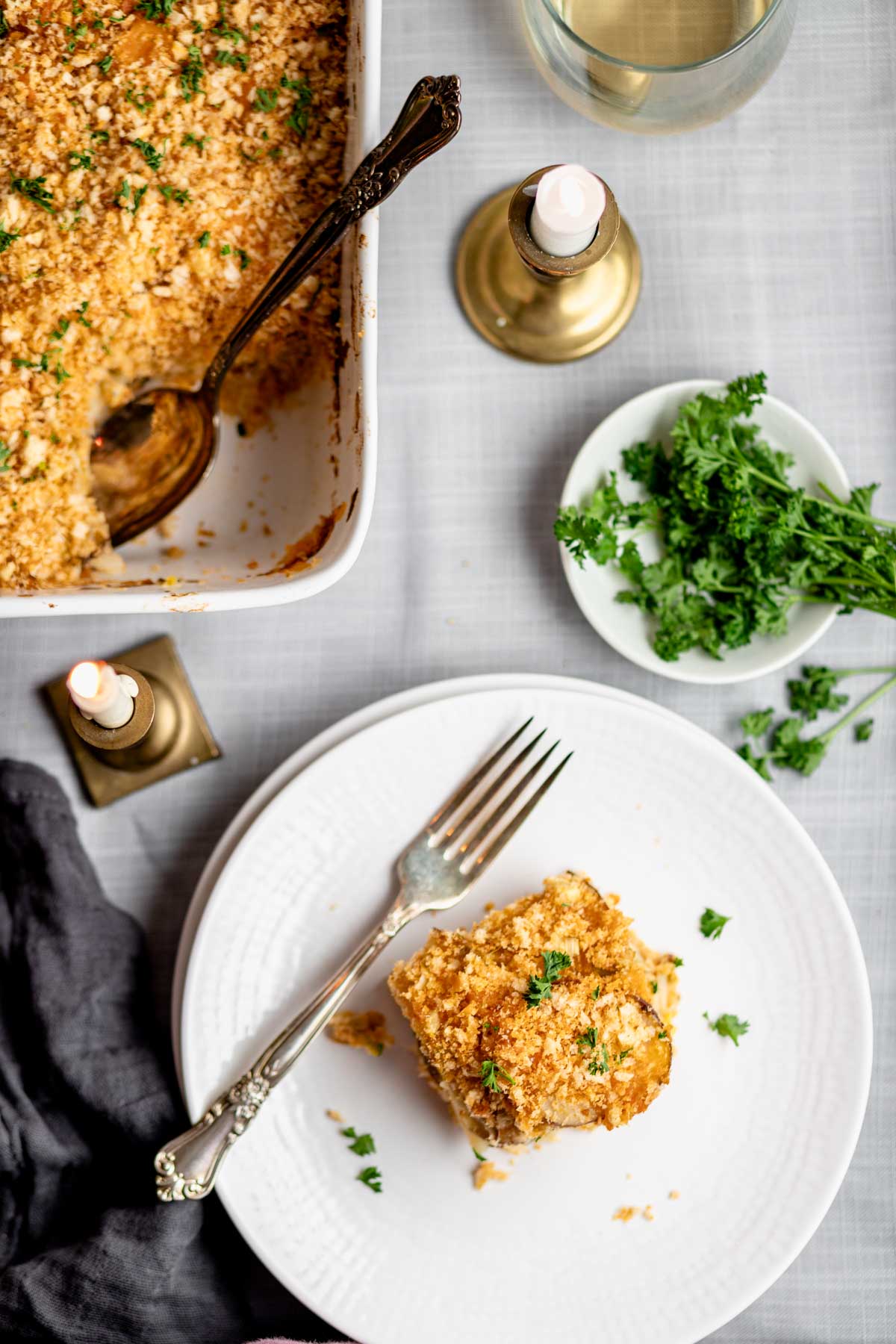 parsnip gratin on circular white plate with fork