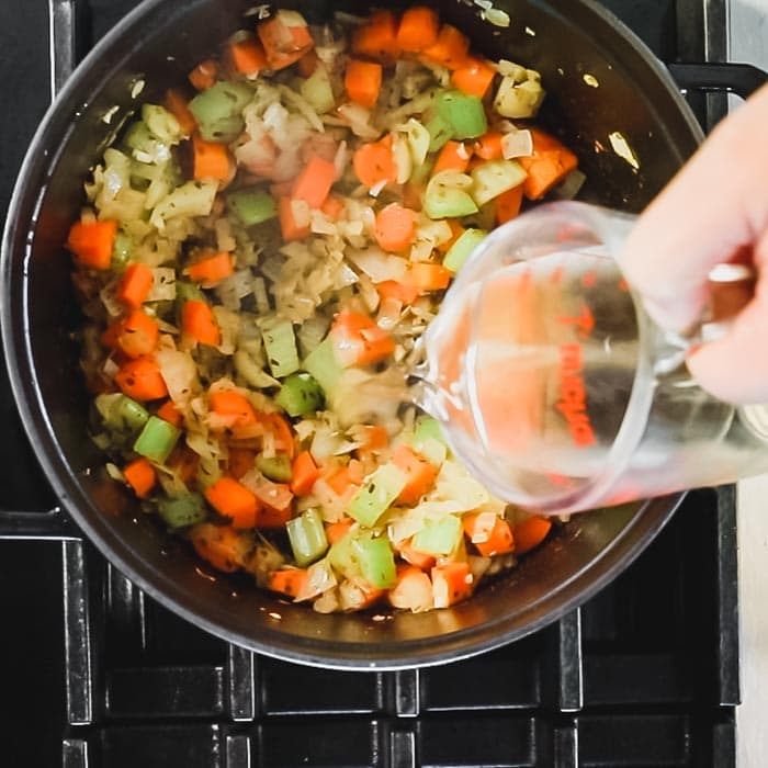 Once the vegetables are soft, add in white wine to deglaze.
