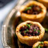 the mini beef wellington appetizers on a silver platter