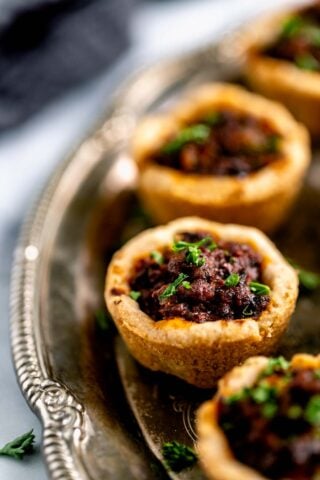 the mini beef wellington appetizers on a silver platter