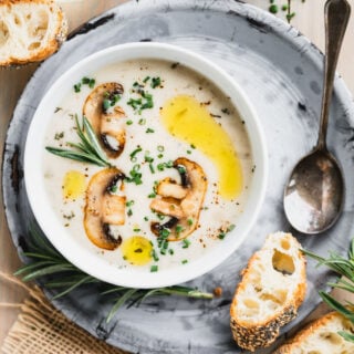 closeup of mushroom soup with herbs and mushrooms on top
