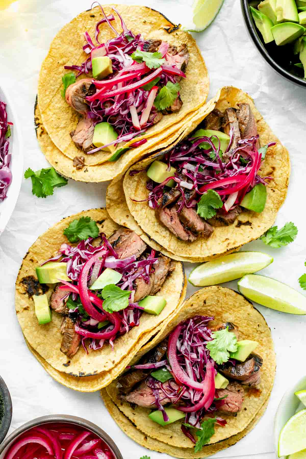 four assembled tacos on a sheet of parchment