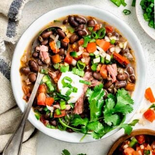 the black bean soup with pico de gallo on top with a spoon in it