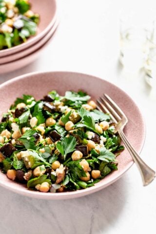 a pink bowl with eggplant salad in it