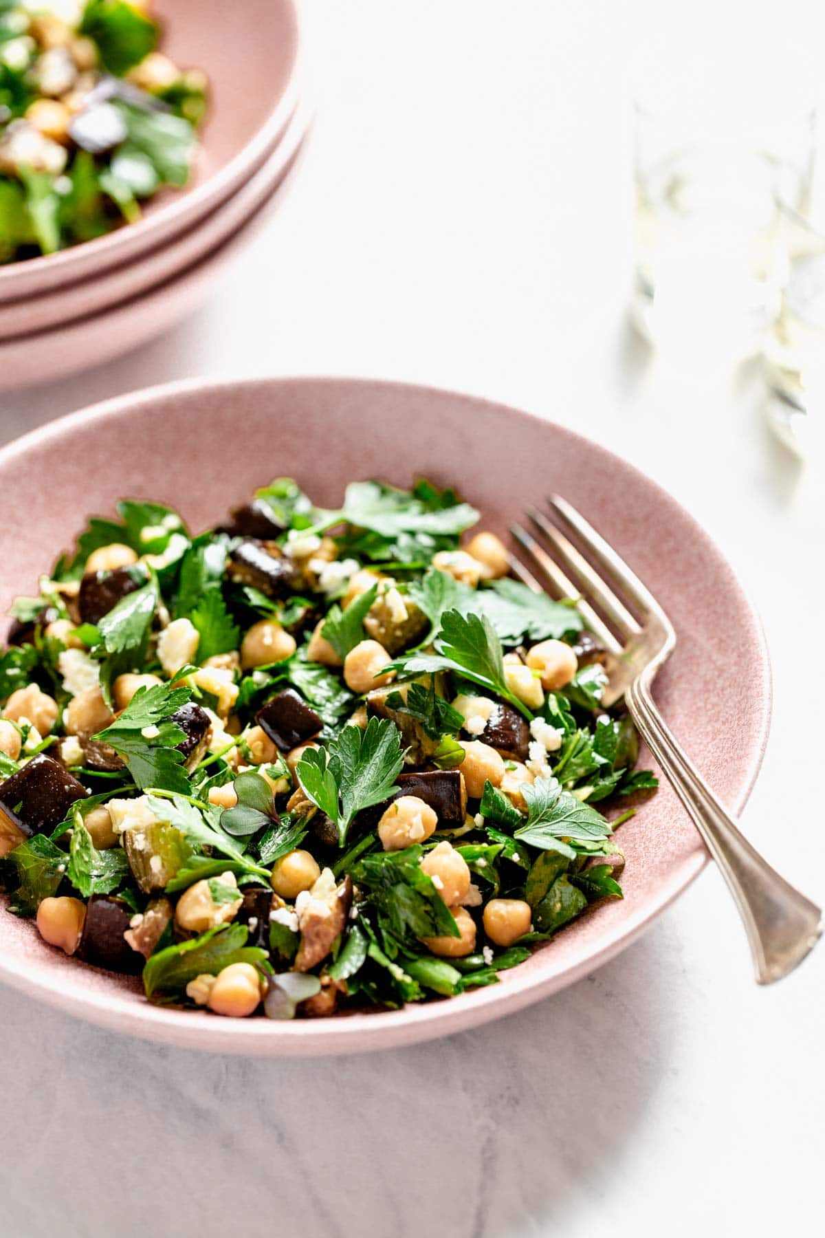 a pink bowl with eggplant salad in it