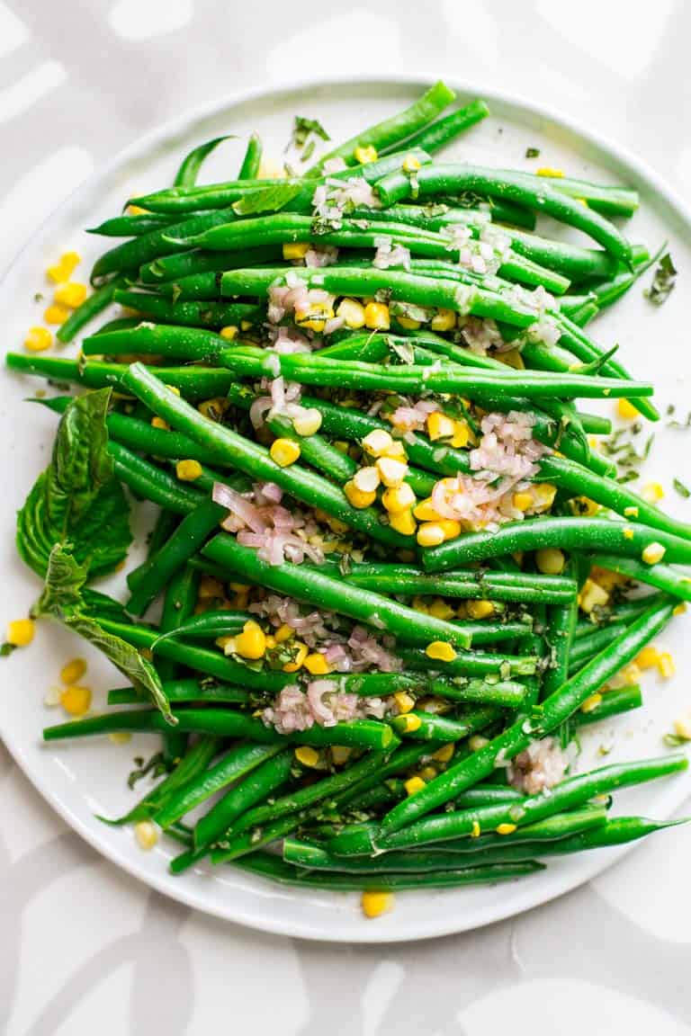 Simple salad made with green beans and sweet corn with cider vinegar and shallot dressing with fresh chopped basil. An easy vegan side salad. Healthy Seasonal Recipes by Katie Webster. #glutenfree #vegan #corn #greenbeans #sidesalad #grainfree #dairyfree #healthy