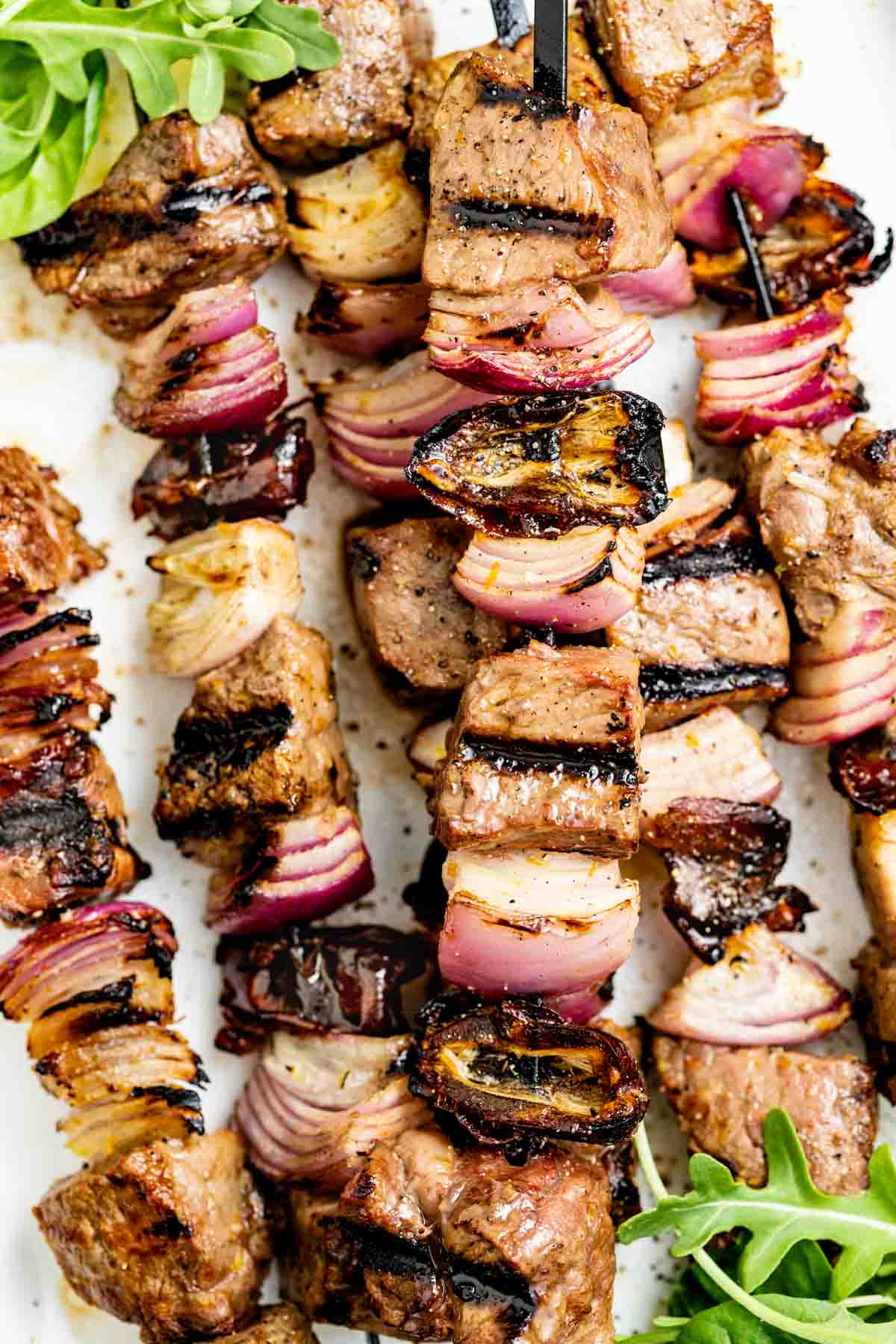 the steak kebabs on a platter from overhead