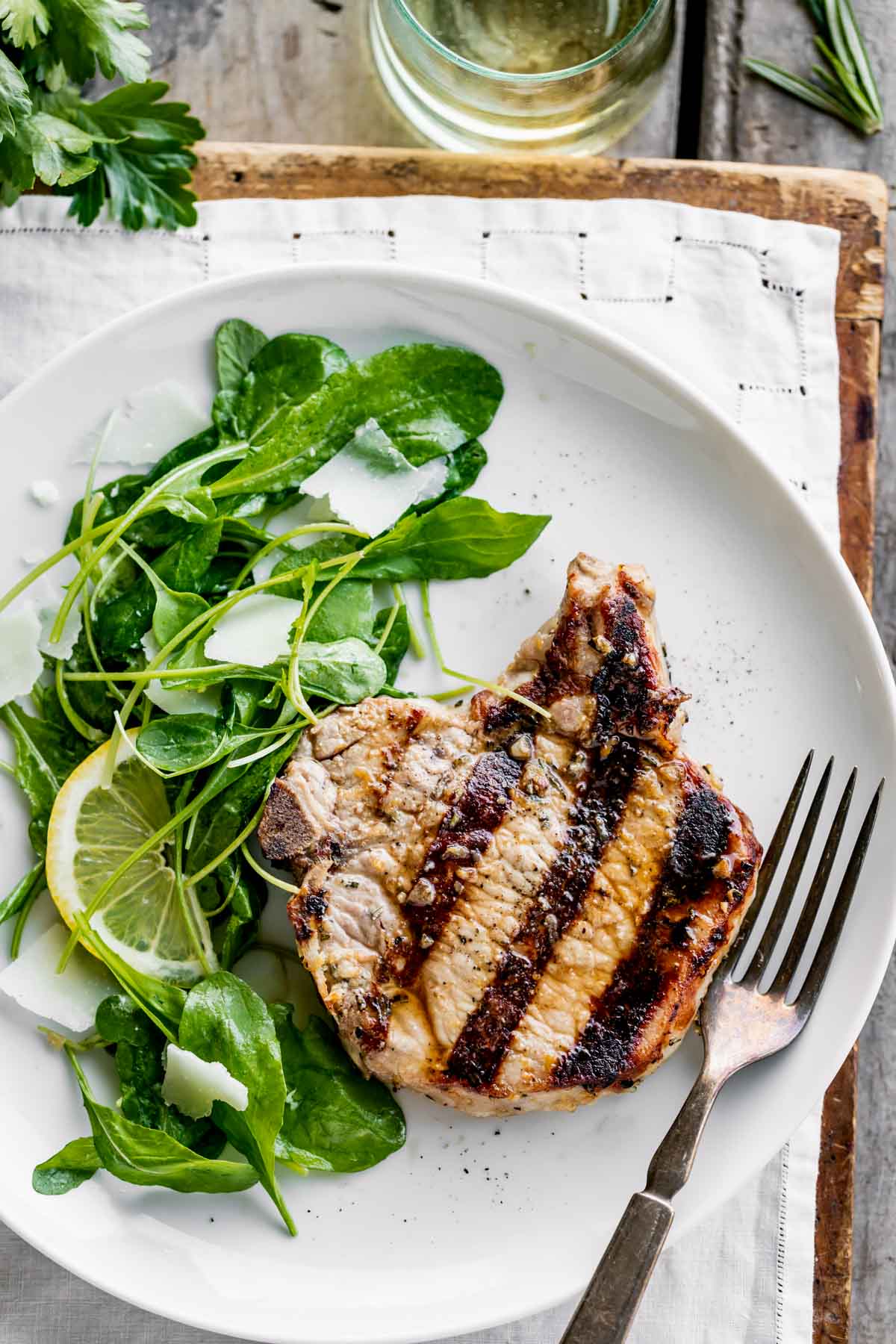 juicy pork on a plate with salad and a fork