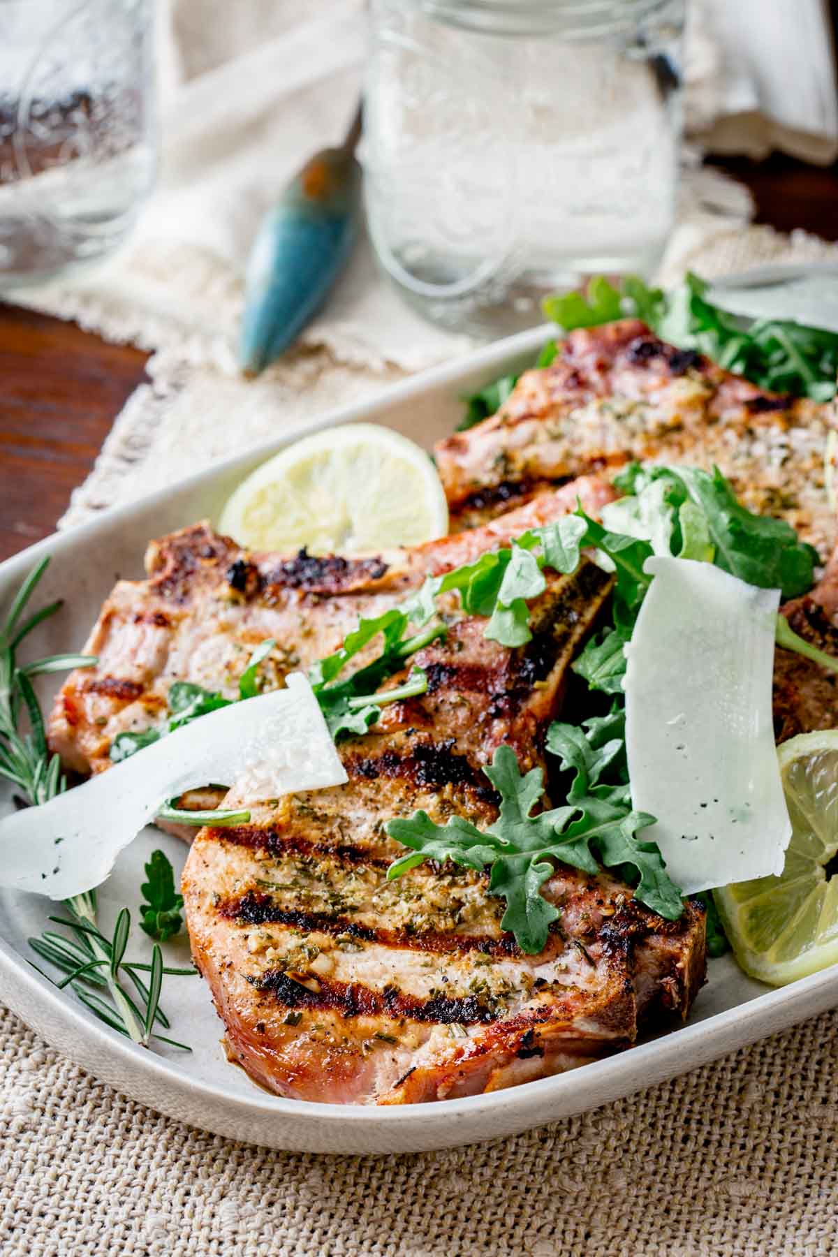 platter of pork with arugula and shaved cheese from side angle