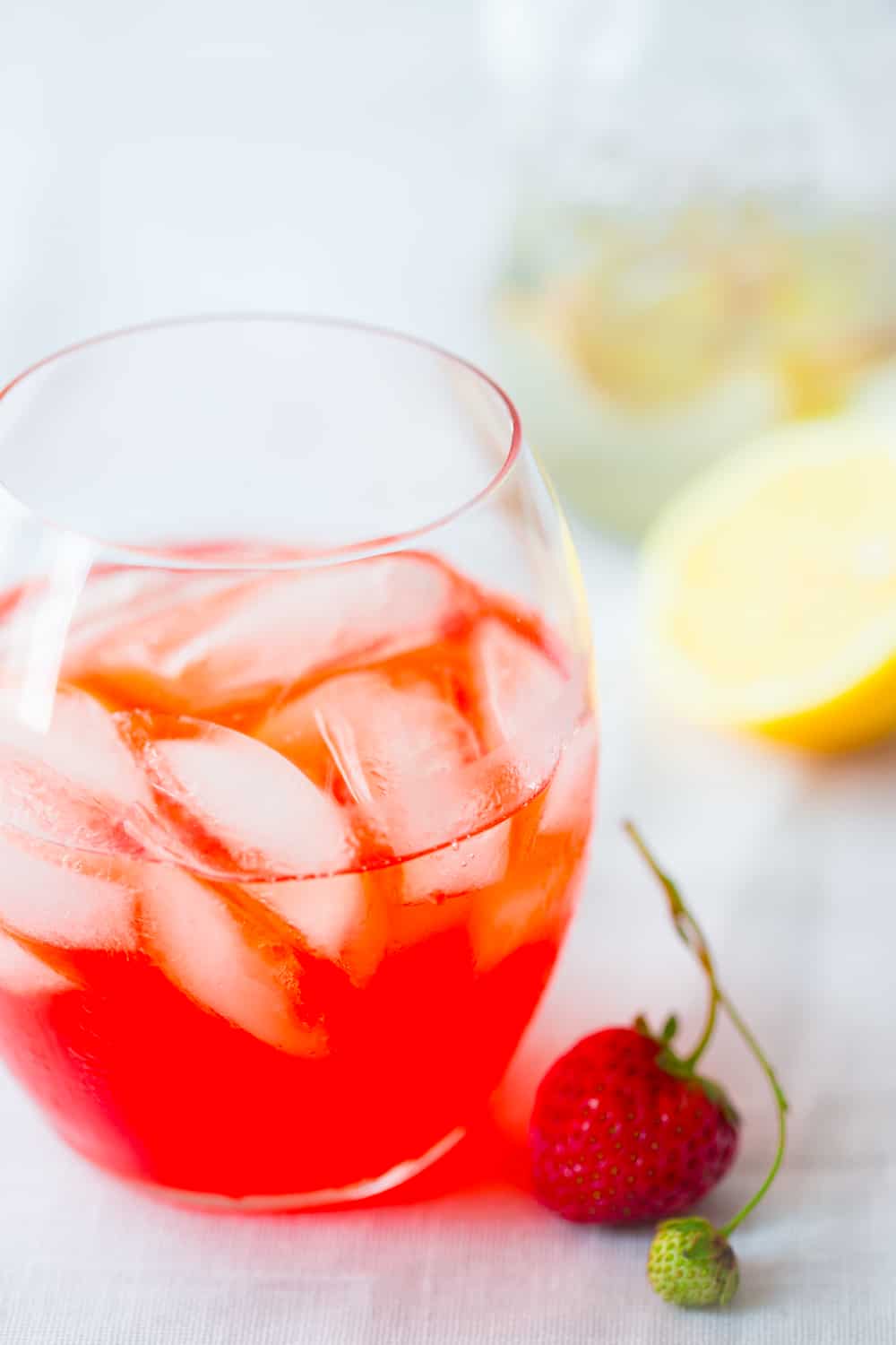 Strawberry Ginger Pink Lemonade Cocktail alongside a strawberry