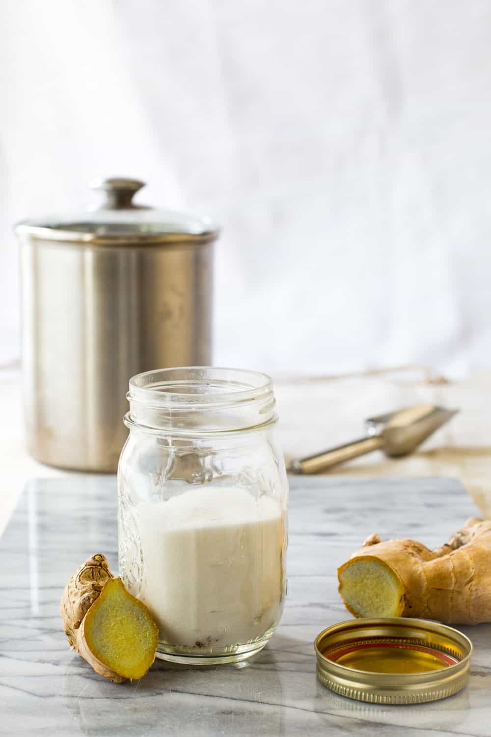 A jar with white granulated sugar and ginger point