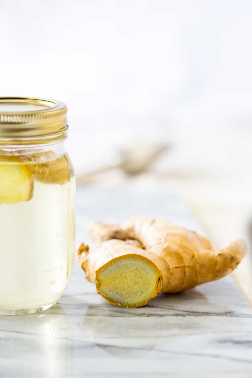 Ginger Simple Syrup next to fresh ginger