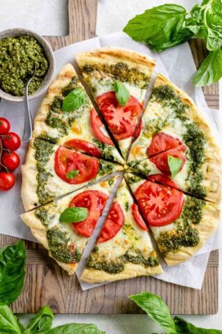 the pesto pizza from overhead with tomatoes on it