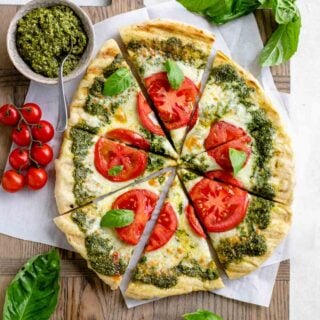 the pesto pizza from overhead with tomatoes on it