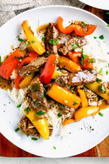 pepper steak in circular white dish over a bed of rice