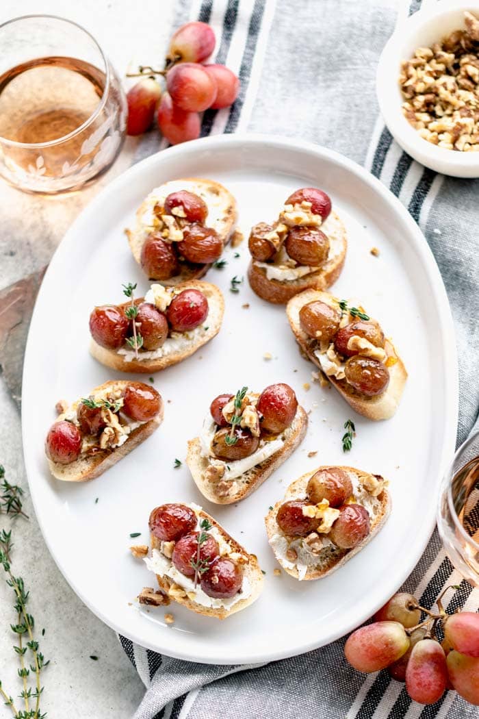 overhead oval platter of crostini with grapes