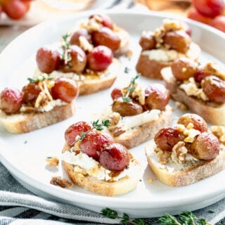 roasted grape crostini on a white platter