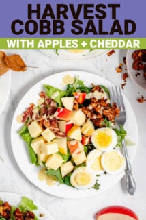 composed salad with eggs, apple and spiced nuts with a fork on a white plate