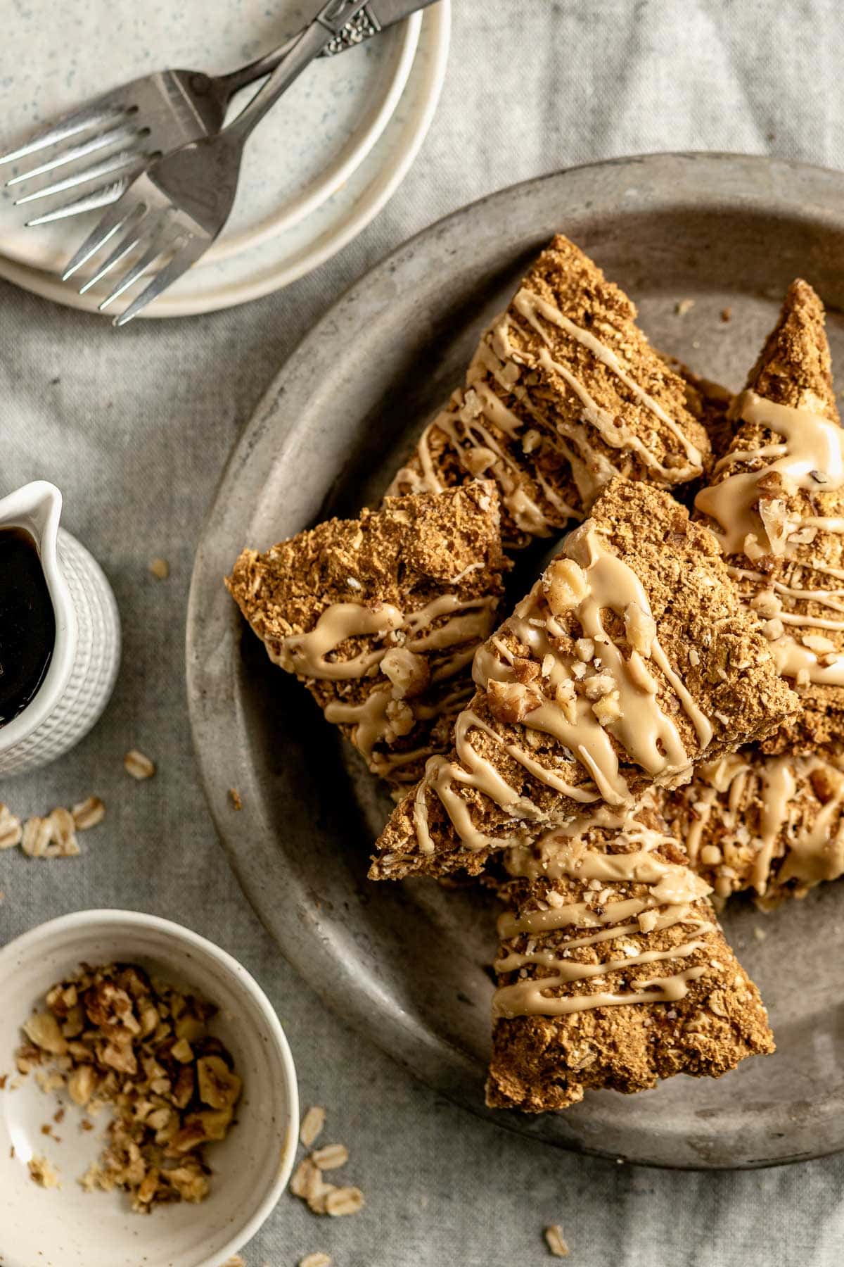 a metal pie tin with pumpkin scones piled in it, and a dish of walnuts