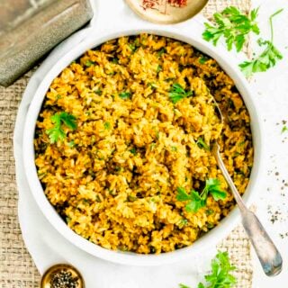 the saffron brown rice from above with a silver spoon resting in it