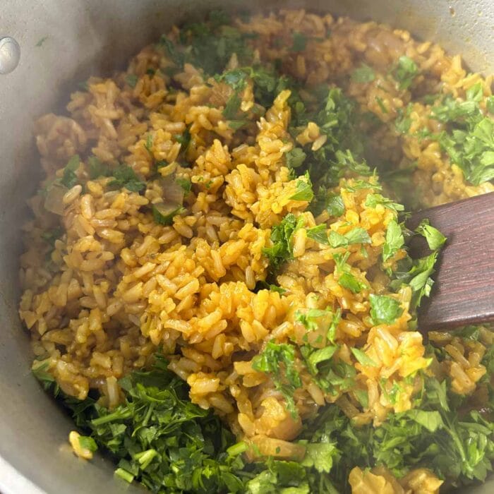 the parsley getting stirred into the rice