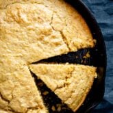 overhead of the cornbread in the skillet with a wedge cut