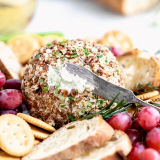 close up of cheese ball with a knife in it
