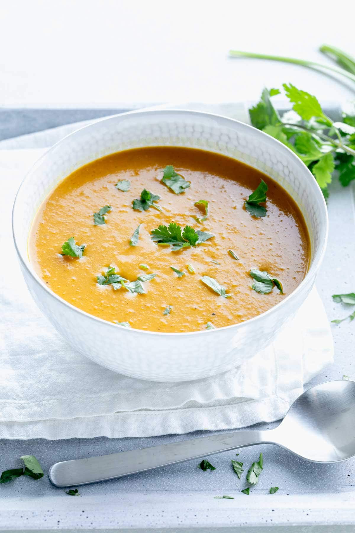 curry soup in a white bowl with cilantro on top