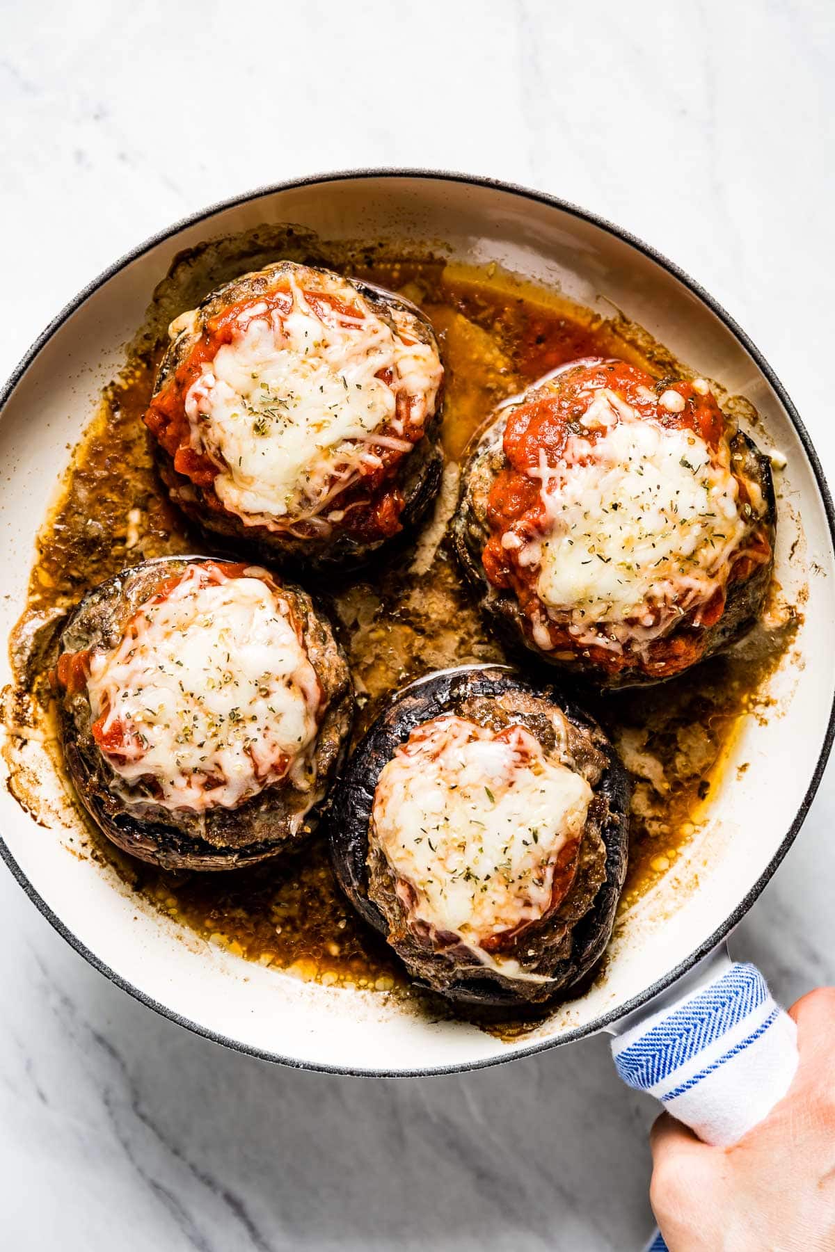 a skillet with cheesy stuffed portobellos