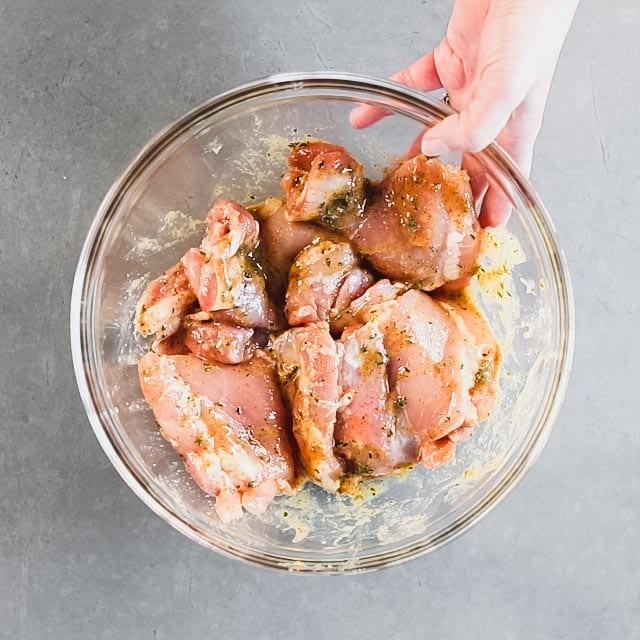 chicken thighs in a bowl coated in honey mustard