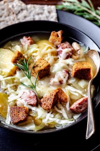 kielbasa and cabbage soup in black bowl